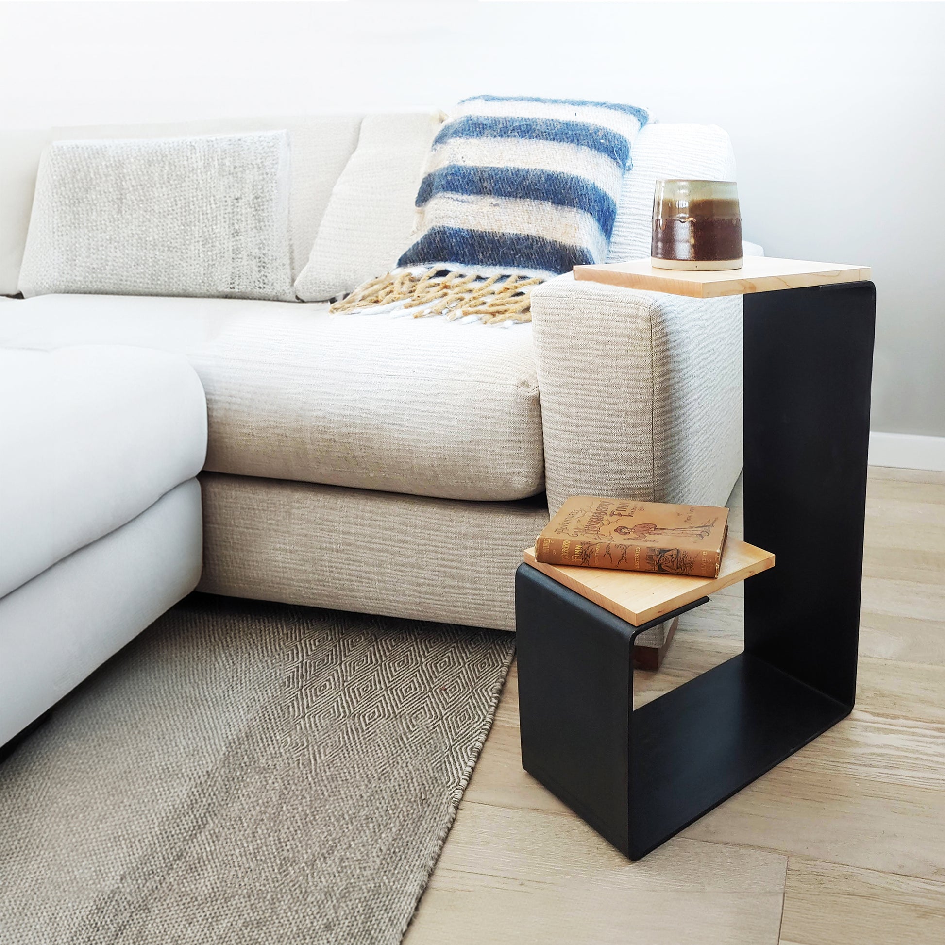 Vermont Woods Studios G Table crafted from natural hardwood, shown close-up with a book and glass for scale.