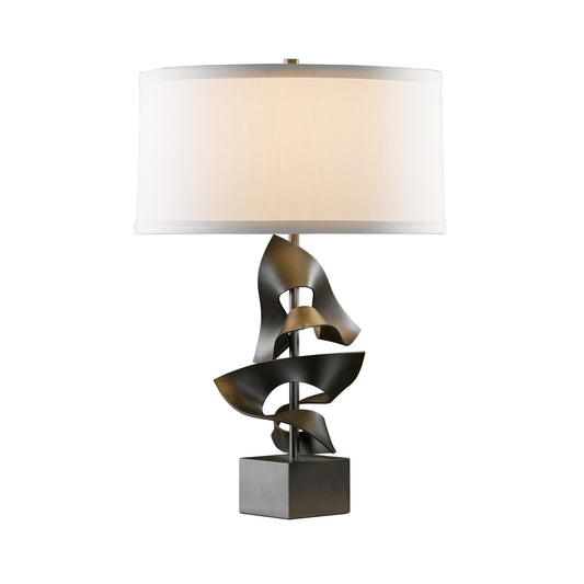 Gallery Two Fold Table Lamp by Hubbardton Forge featuring a sculptural metallic base and white drum shade in a modern, artisan-crafted design.