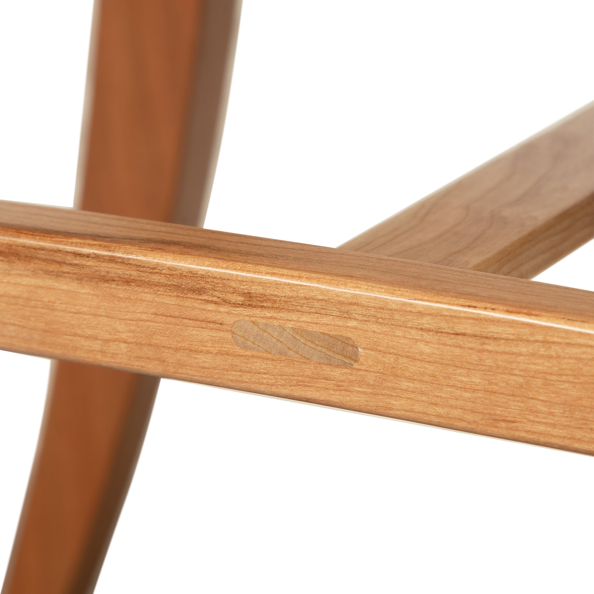 Close-up of the expertly crafted Grafton Chair leg joint by Vermont Woods Studios, highlighting the wood plug and fine natural wood finish.