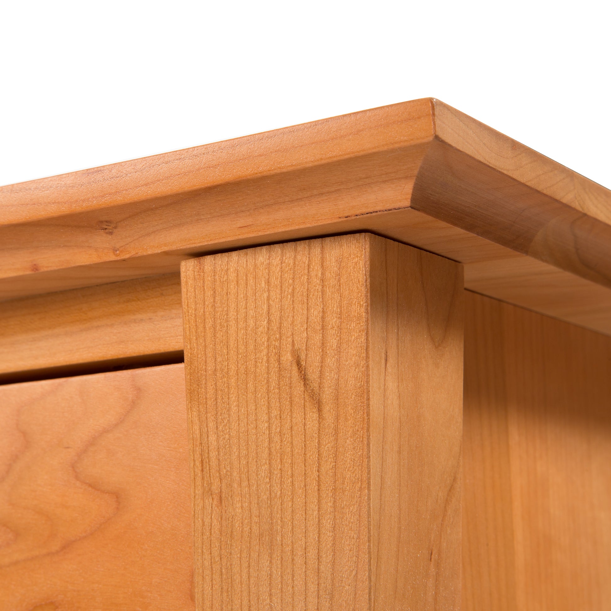 A close up of the top of a wooden Lyndon Furniture Green Mountain 3-Drawer Nightstand.