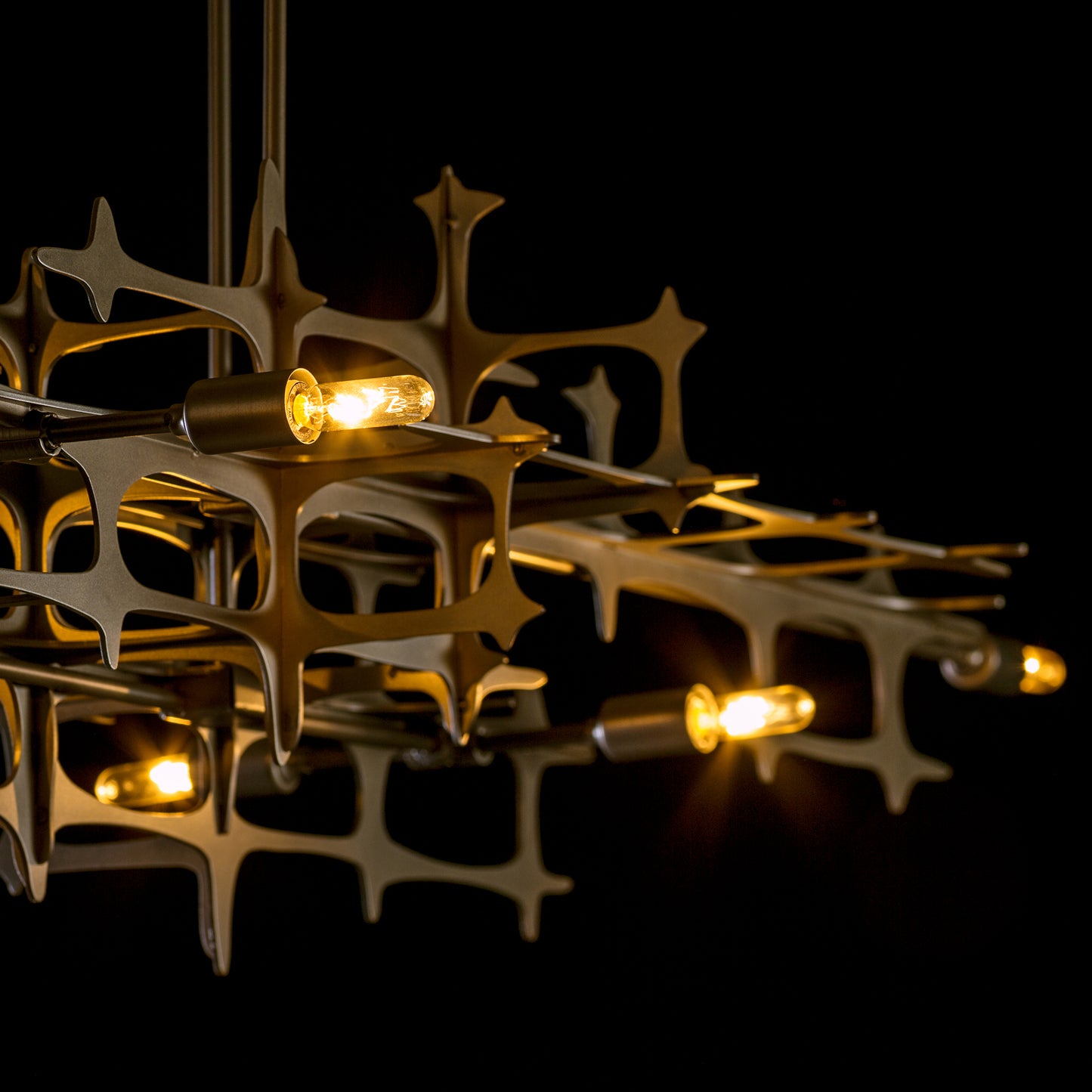 Grid Pendant light by Hubbardton Forge showcasing star-shaped metal frames with glowing bulbs, embodying a sleek industrial design.