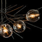A Hubbardton Forge Griffin Pendant featuring four elegant Simon Pearce glass balls hanging from it.
