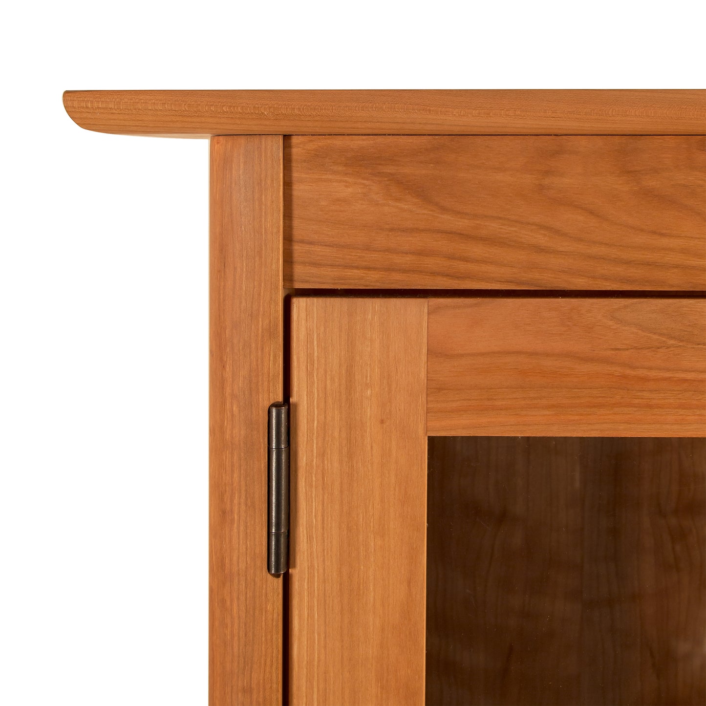 Detail view of the Heartwood Shaker 2-Glass Door Bookcase by Vermont Furniture Designs, highlighting the handcrafted wood, hinge, and glass door panel.