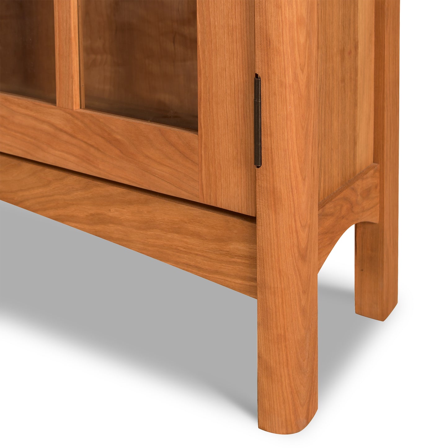 Heartwood Shaker 2-Glass Door Bookcase featuring an arched leg and hinge detail, highlighting Vermont Furniture Designs’ fine craftsmanship.
