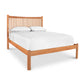 A wooden Vermont Furniture Designs Heartwood Shaker Low Footboard Bed frame with a slatted headboard, furnished with a white mattress and two pillows with white pillowcases, isolated on a white background.