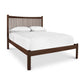 A Heartwood Shaker Low Footboard Bed by Vermont Furniture Designs with white bedding and two pillows.