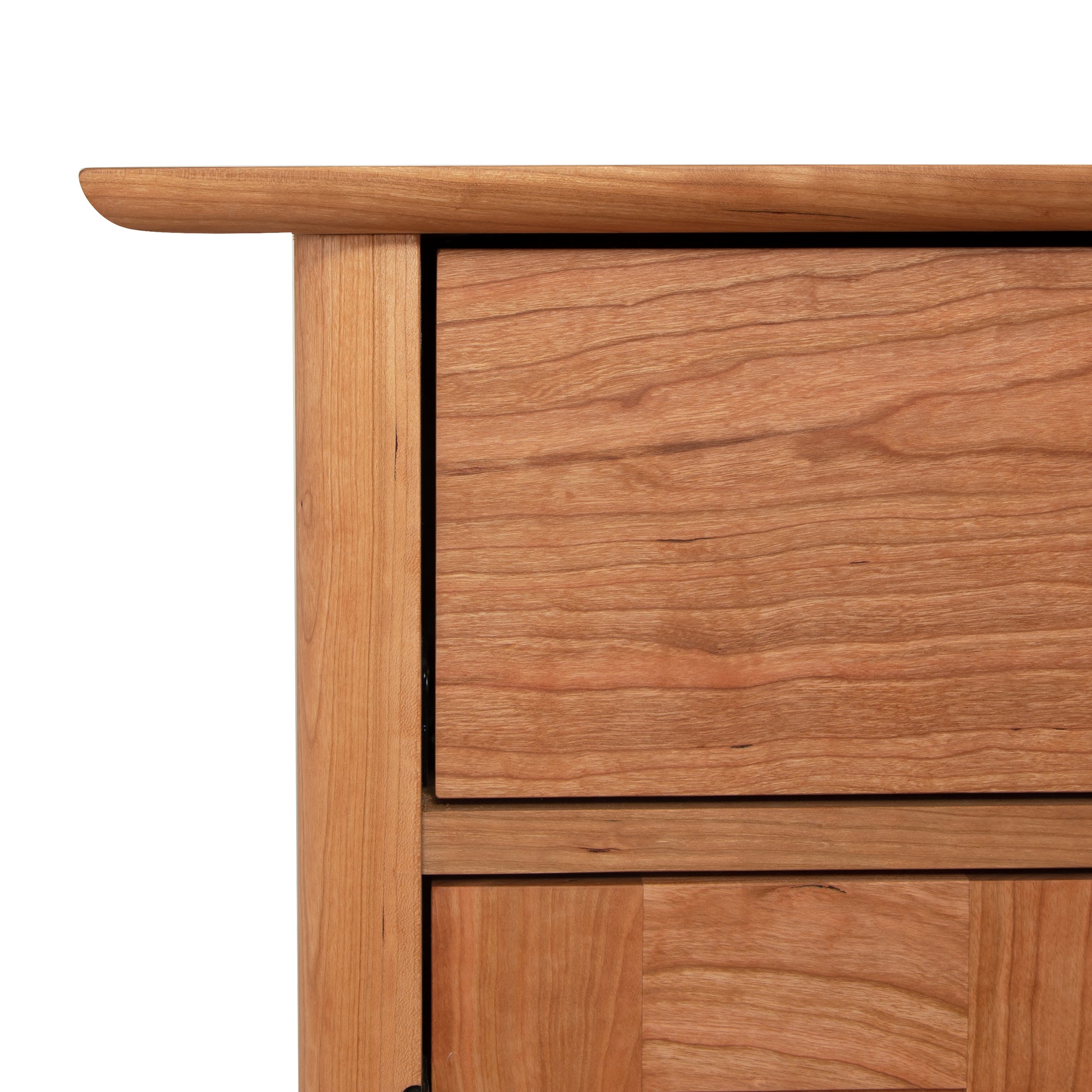Close-up of a Heartwood Shaker Short Storage Chest drawer with a visible handle, showcasing wood grain texture, against a white background by Vermont Furniture Designs.