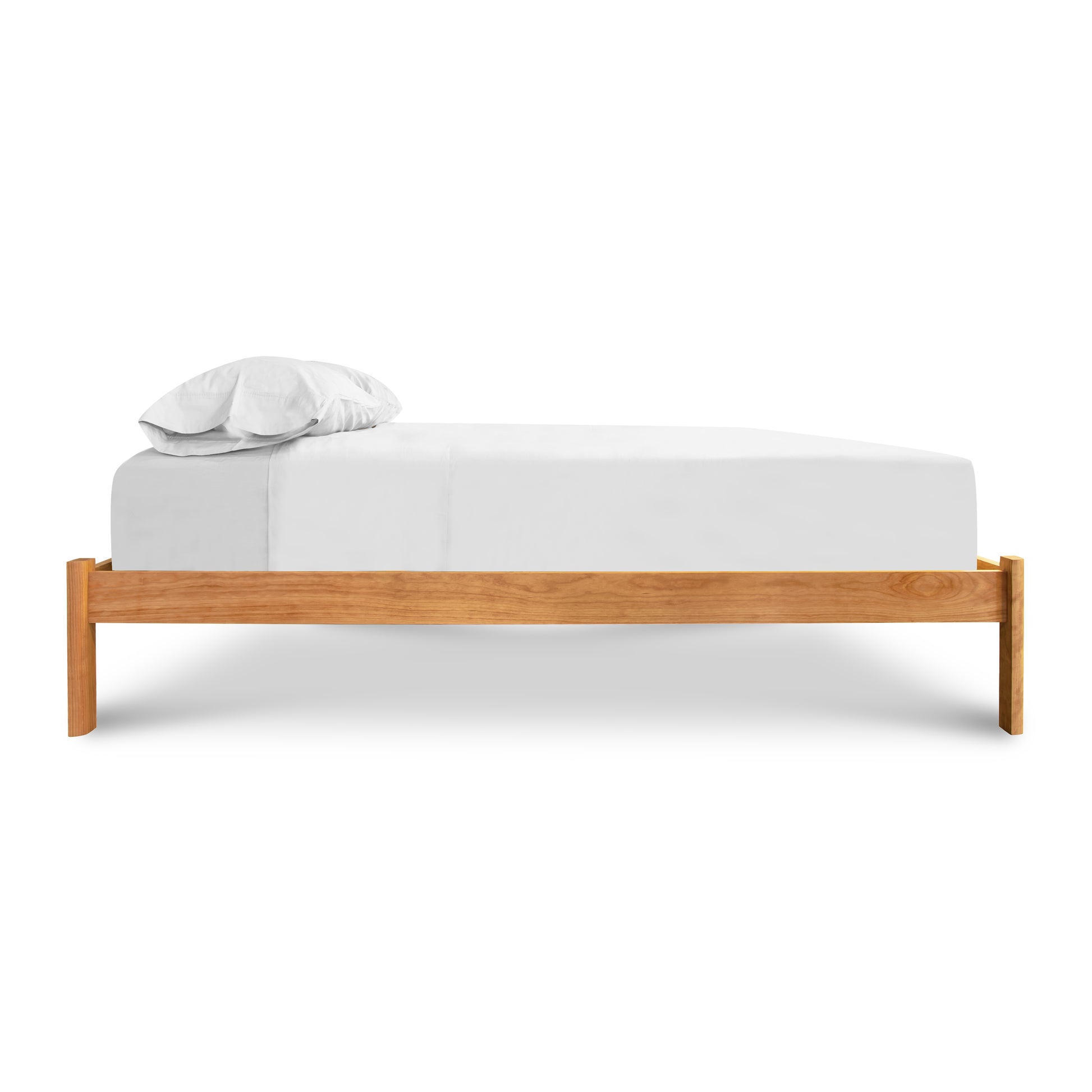 Vermont Furniture Designs Heartwood Shaker Studio-Style Platform Bed featuring a minimalist, elegant design with a white sheet and pillow.