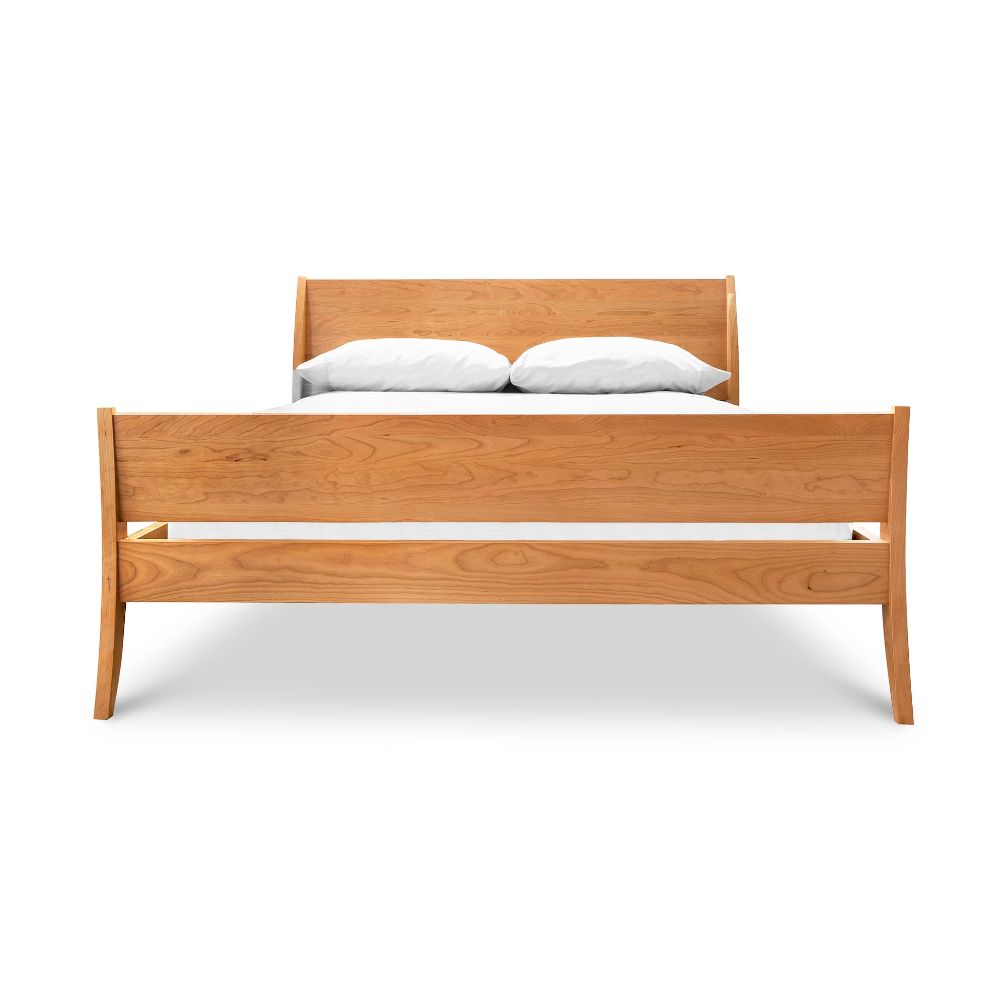 The Lyndon Furniture Holland Sleigh Bed offers a contemporary twist on a classic design, featuring solid wood options and pristine white sheets.