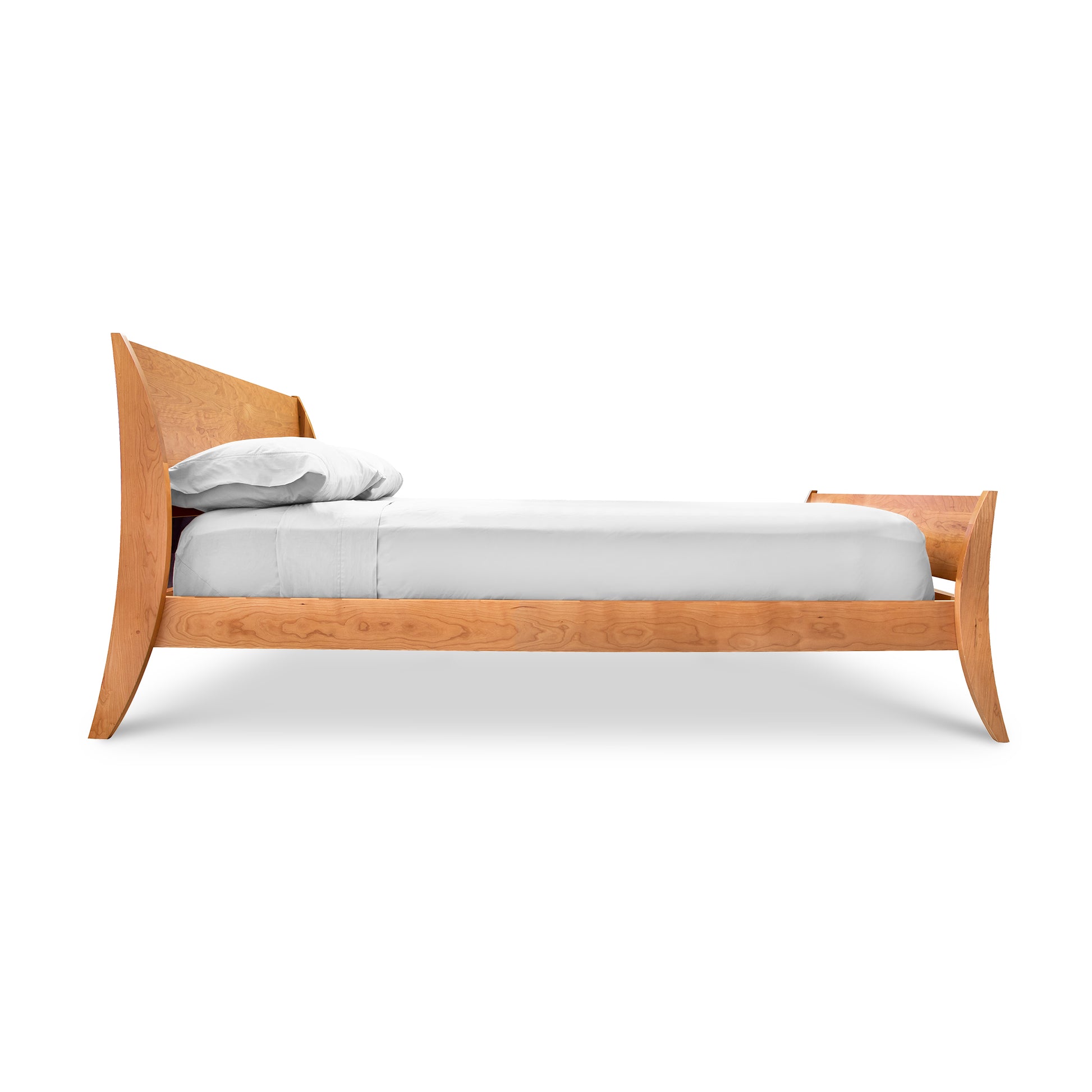 The Lyndon Furniture Holland Sleigh Bed is an elegant bedroom centerpiece with a contemporary twist. It features a bed frame made of wood, including a wooden headboard and footboard.