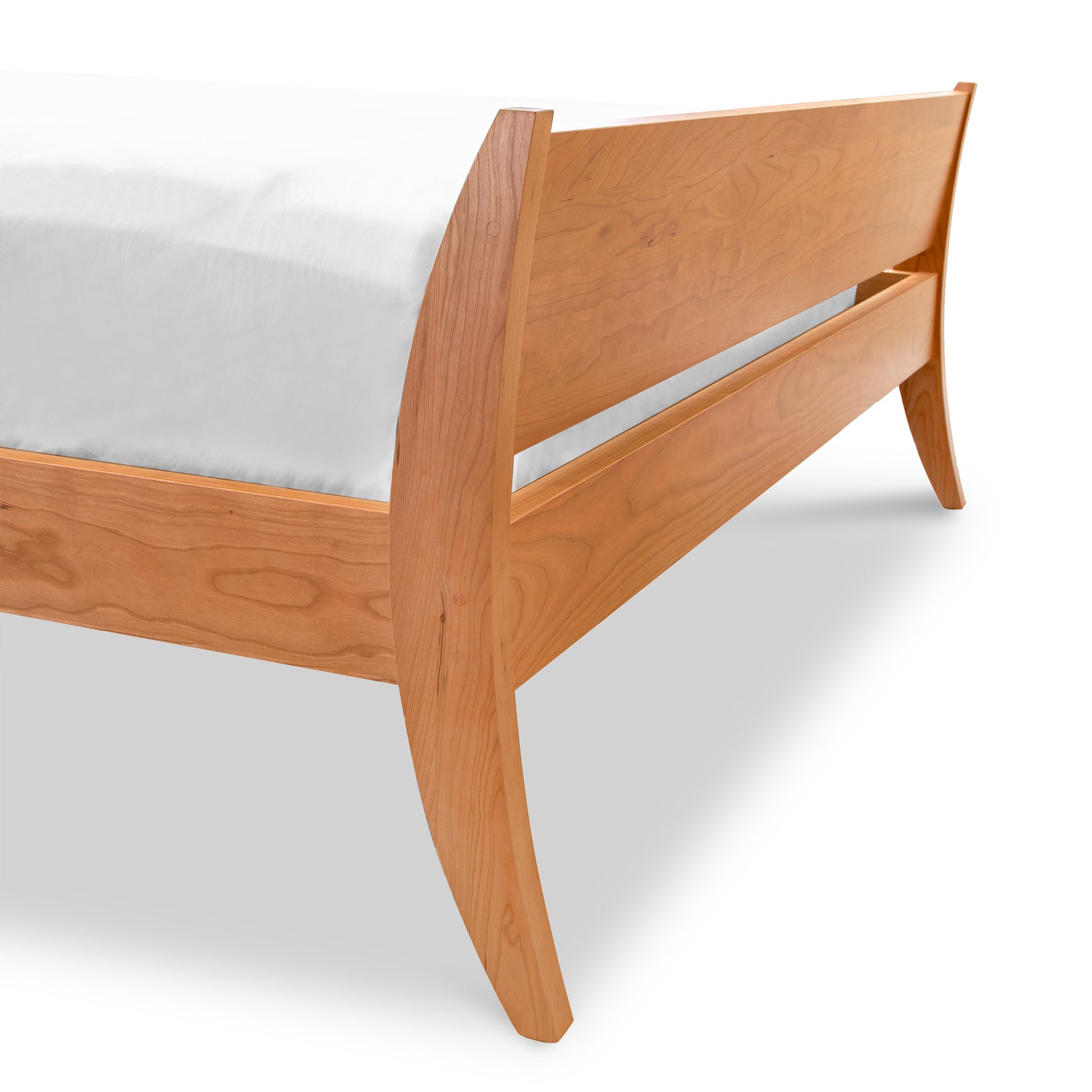 The Lyndon Furniture Holland Sleigh Bed is an elegant bedroom centerpiece that combines a contemporary twist with a wooden bed frame and a white sheet.