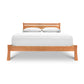 A wooden Vermont Furniture Designs Horizon Platform Bed frame with a white mattress and two pillows against a white background, finished with eco-friendly oil.