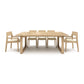 A solid oak Copeland Furniture Iso Extension Dining Table with six matching chairs on a white background.