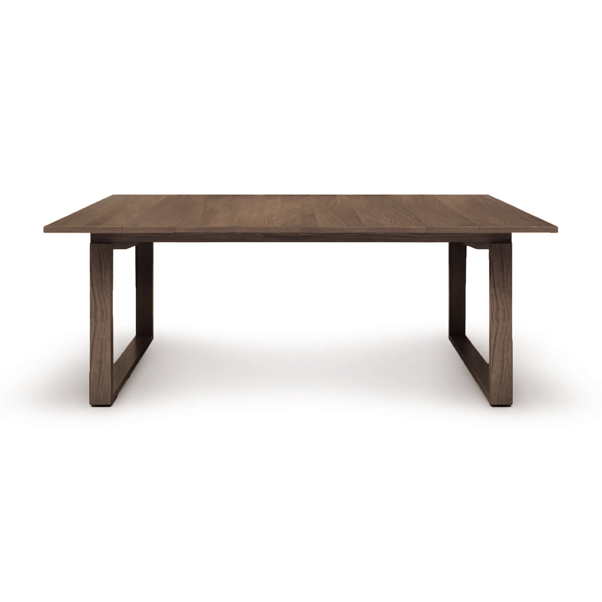 A simple Iso Extension Dining Table by Copeland Furniture, with a rectangular top and sturdy legs made of solid oak wood, isolated on a white background.