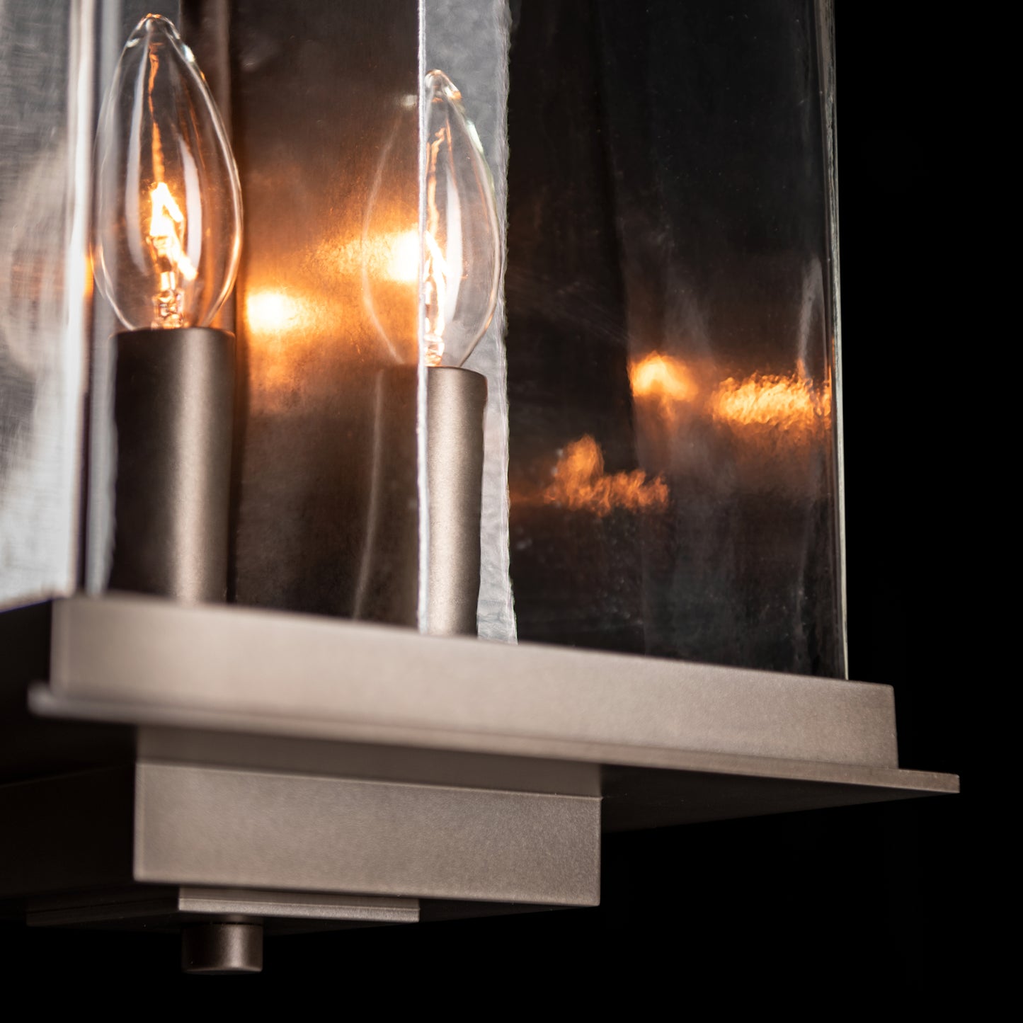 Hubbardton Forge Kingston Outdoor Large Lantern featuring two candle bulbs and clear glass panels, showcasing its elegant craftsmanship.