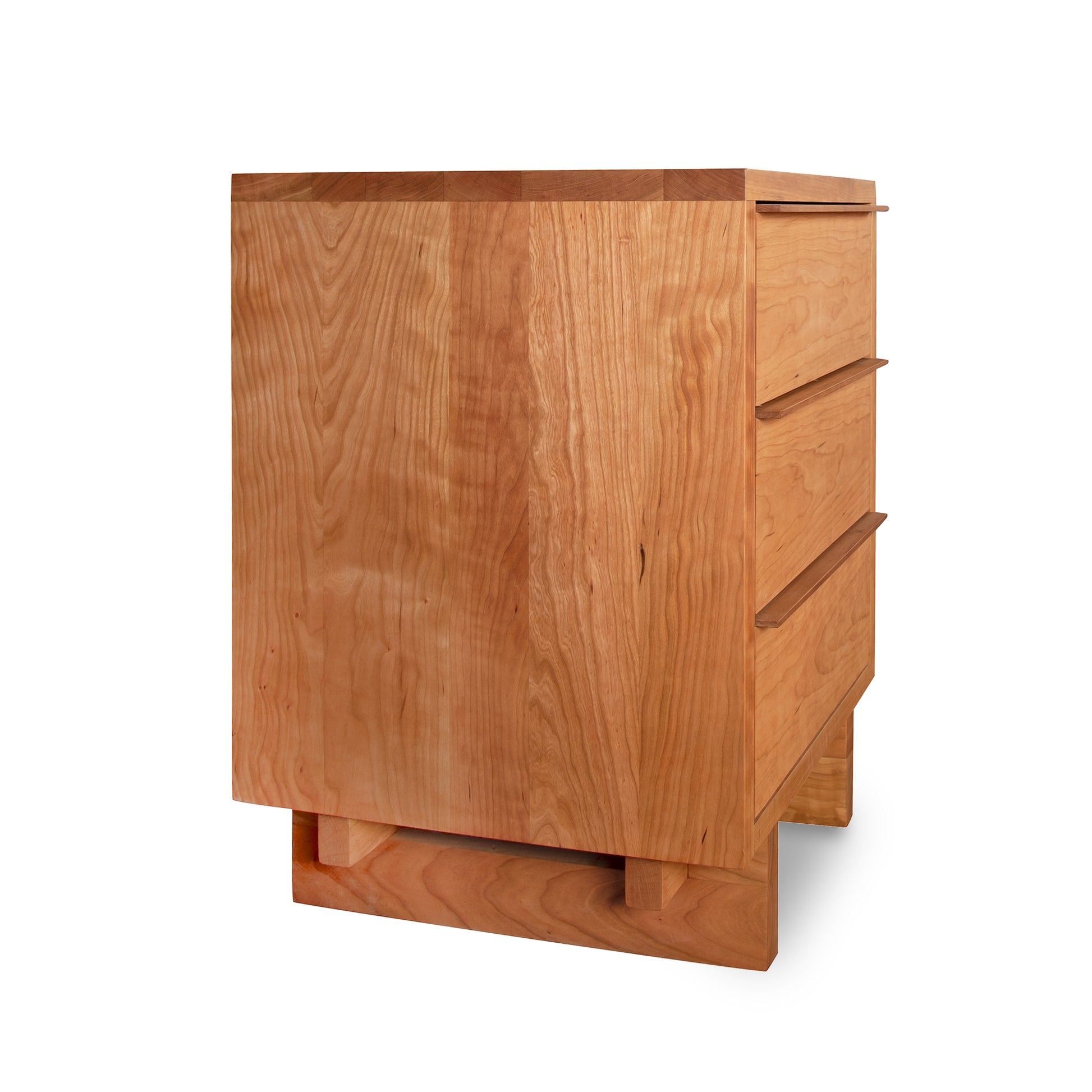 A natural cherry Vermont Furniture Designs Kipling 3-Drawer Nightstand with one drawer partially open, isolated on a white background.