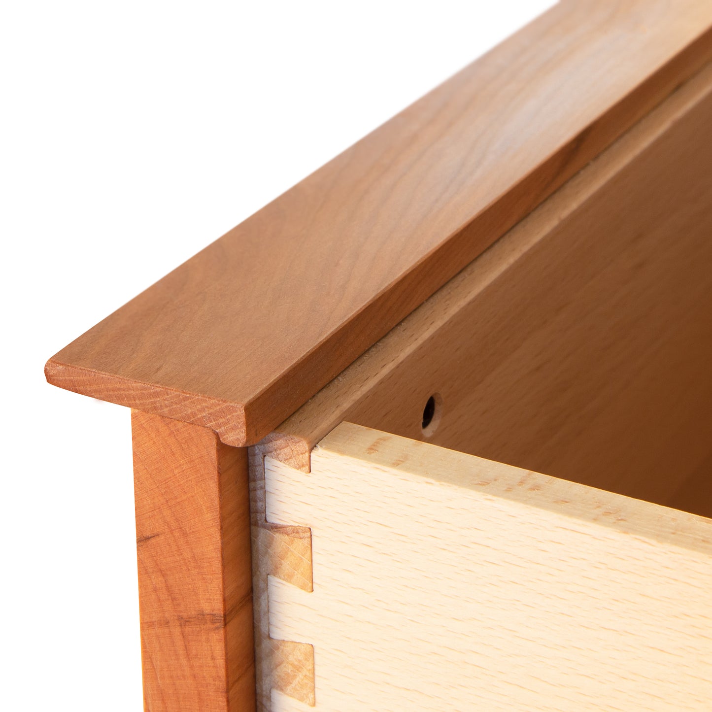 A close-up view of the Vermont Furniture Designs Kipling 3-Drawer Nightstand showing dovetail joint details in natural cherry.