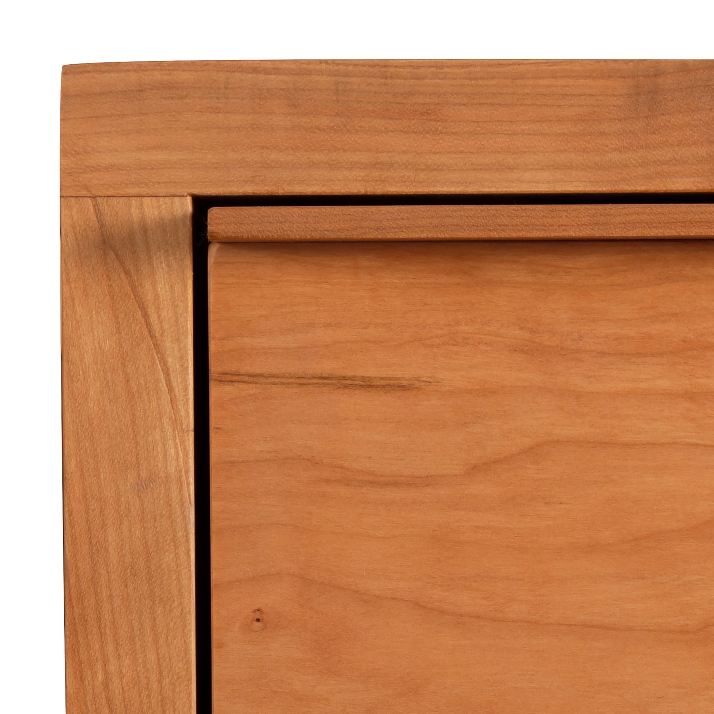 Close-up view of a Vermont Furniture Designs Kipling 3-Drawer Nightstand corner showing the grain and joint work in natural cherry.