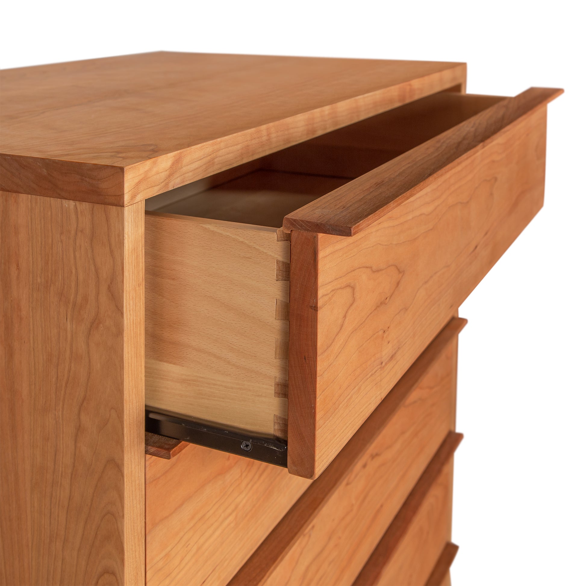 Vermont craftsmanship imbues the Vermont Furniture Designs Kipling 5-Drawer Wide Chest, a handcrafted furniture piece featuring a wooden dresser with an open drawer revealing its meticulous construction and metal slide mechanism.