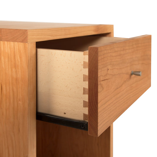 A Vermont Furniture Designs Larssen 1-Drawer Enclosed Shelf Nightstand made from natural hardwoods is partially open, revealing its dovetail joint construction and a simple knob handle, against an isolated background.