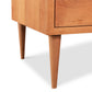 Wooden Larssen 8-Drawer Dresser corner with tapered legs, featuring solid wood construction, on a white background. (Brand Name: Vermont Furniture Designs)