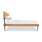 A Larssen Bed by Vermont Furniture Designs with a white mattress and pillows, isolated on a white background.