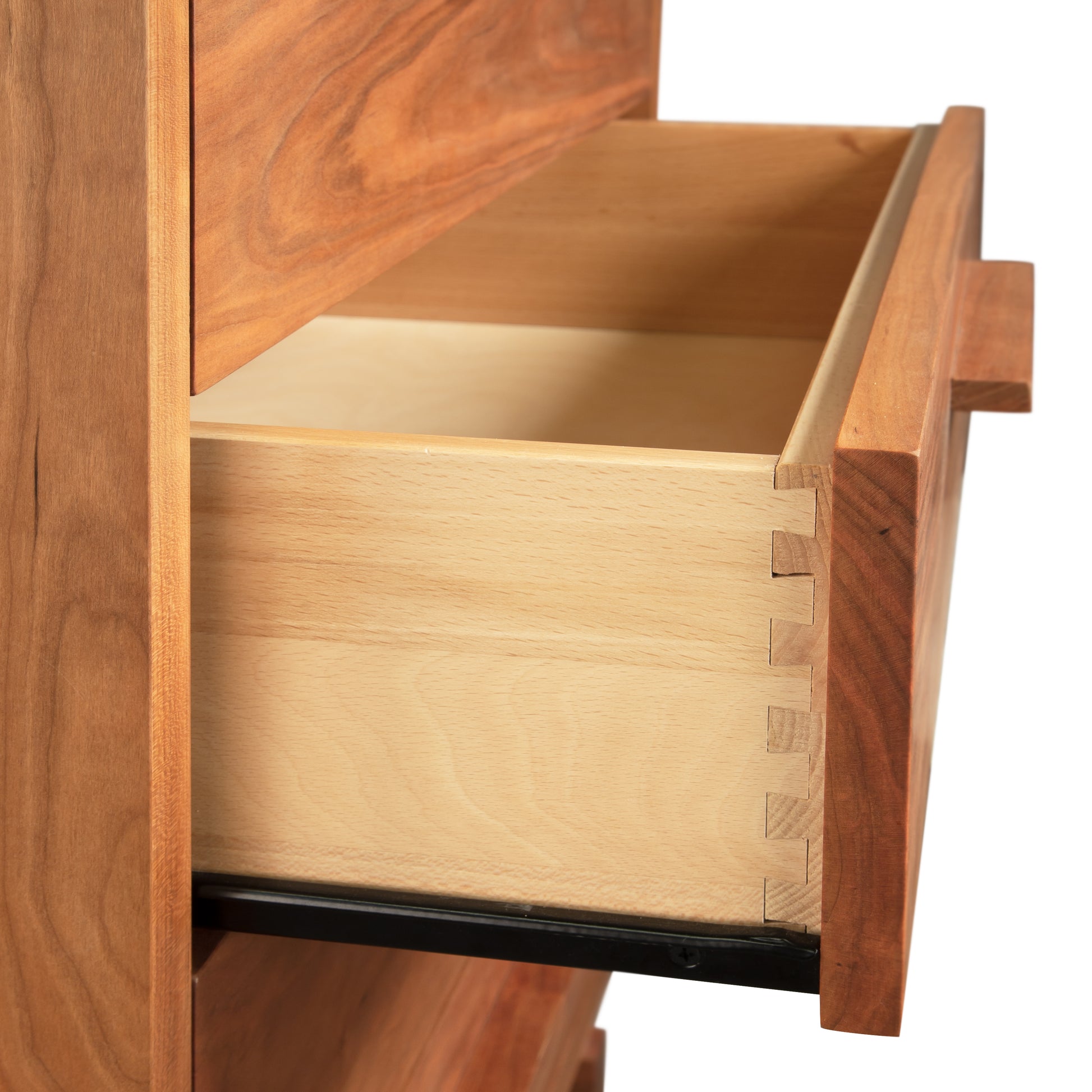 A Vermont Furniture Designs Loft 5-Drawer Chest's open wooden drawer, showcasing Vermont craftsmanship with dovetail joints at the corner, made from natural solid hardwood.