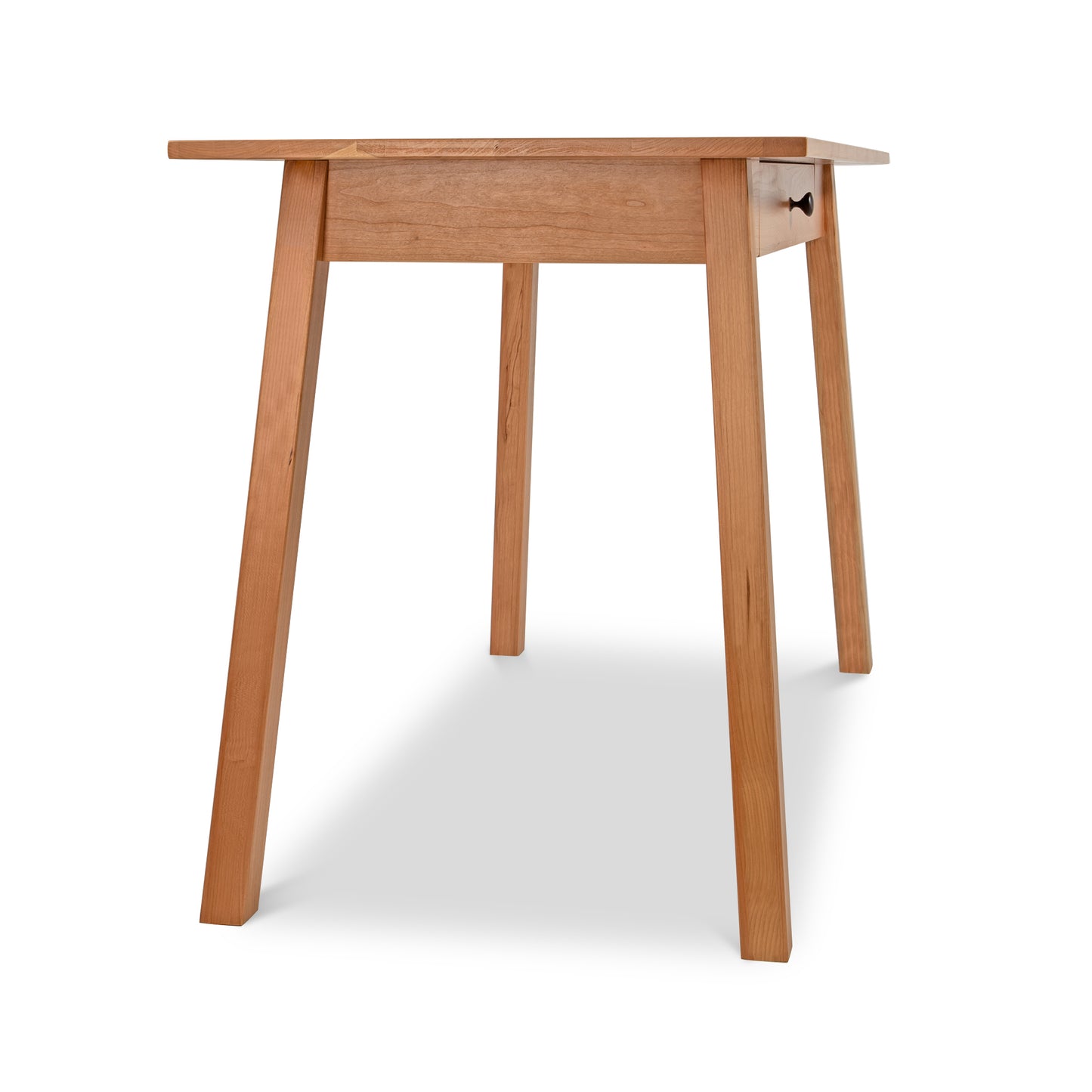 Alt text: Manchester Writing Desk by Vermont Woods Studios - Sustainable Solid Wood Furniture with Light Brown Finish, Modern Home Office Table featuring Four Legs and a Drawer.