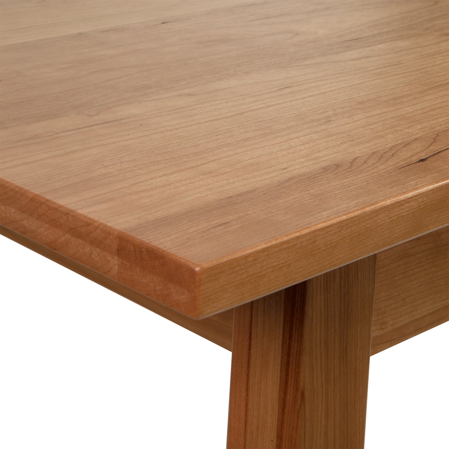 Close-up of the Manchester Writing Desk by Vermont Woods Studios, showcasing a solid wood tabletop and leg with a natural wood finish. Ideal for mid-century modern home offices, this American-made desk features sustainable cherry or walnut wood with smooth, rounded edges and visible grain patterns.