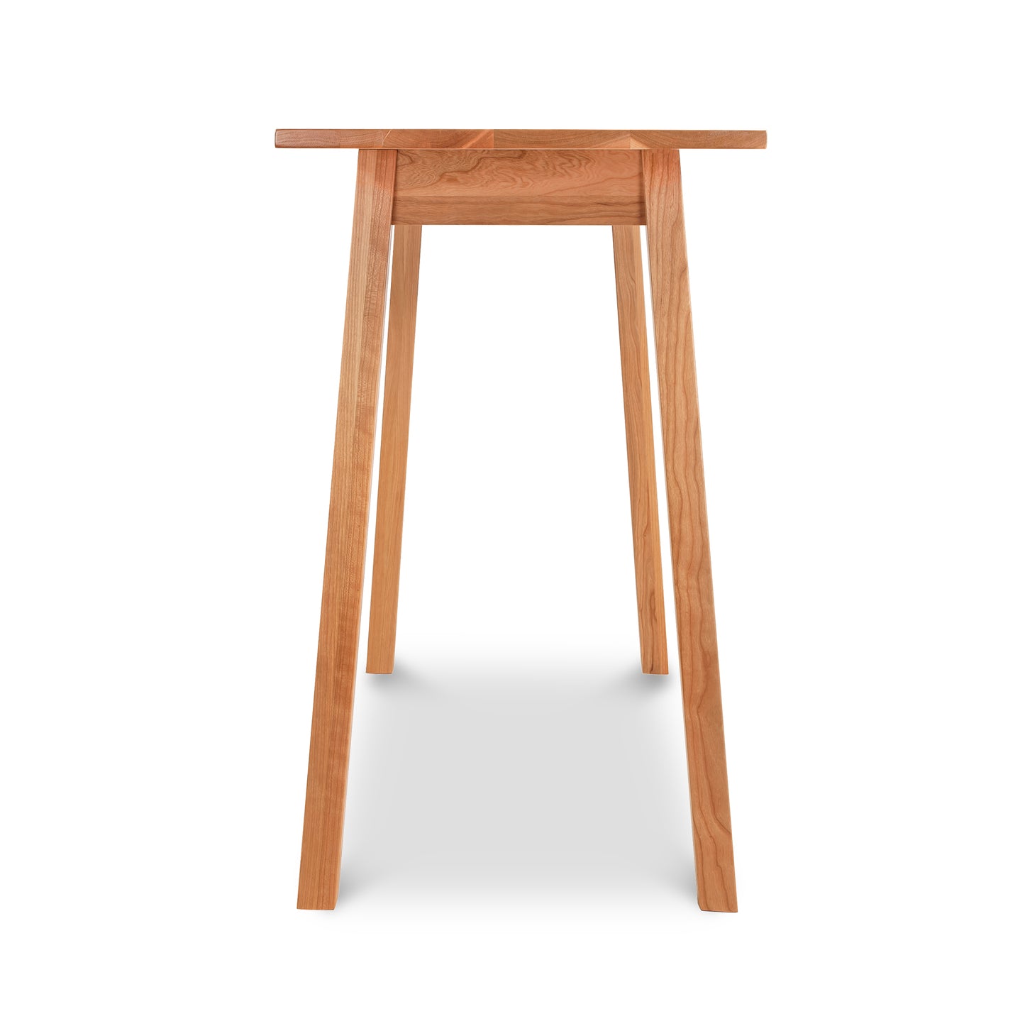 Manchester Compact Desk from the Manchester Furniture Collection by Vermont Woods Studios: A tall solid wood bar table with a minimalist design, featuring four outward-angled legs for stability. The rectangular tabletop showcases a natural wood finish with visible grain and texture. Ideal as an American made compact desk or furniture piece, this cherry wood or walnut wood option enhances any space with its sustainable craftsmanship.