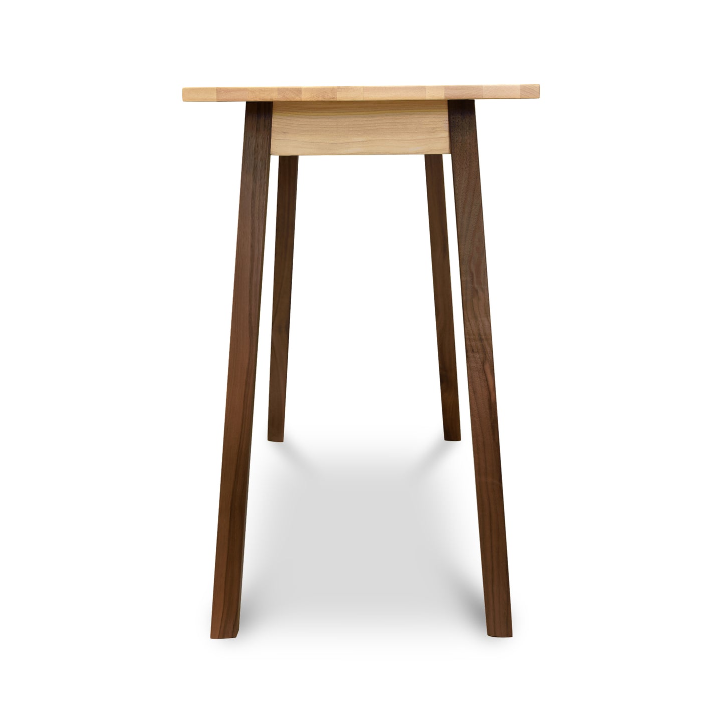 Handcrafted solid wood desk with light cherry wood top and darker walnut angled legs. The Manchester Two-Tone Compact Desk by Vermont Woods Studios features a minimalist design and flared legs for stability, ideal for modern American made furniture enthusiasts.