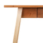A wooden desk with two legs and a drawer.
