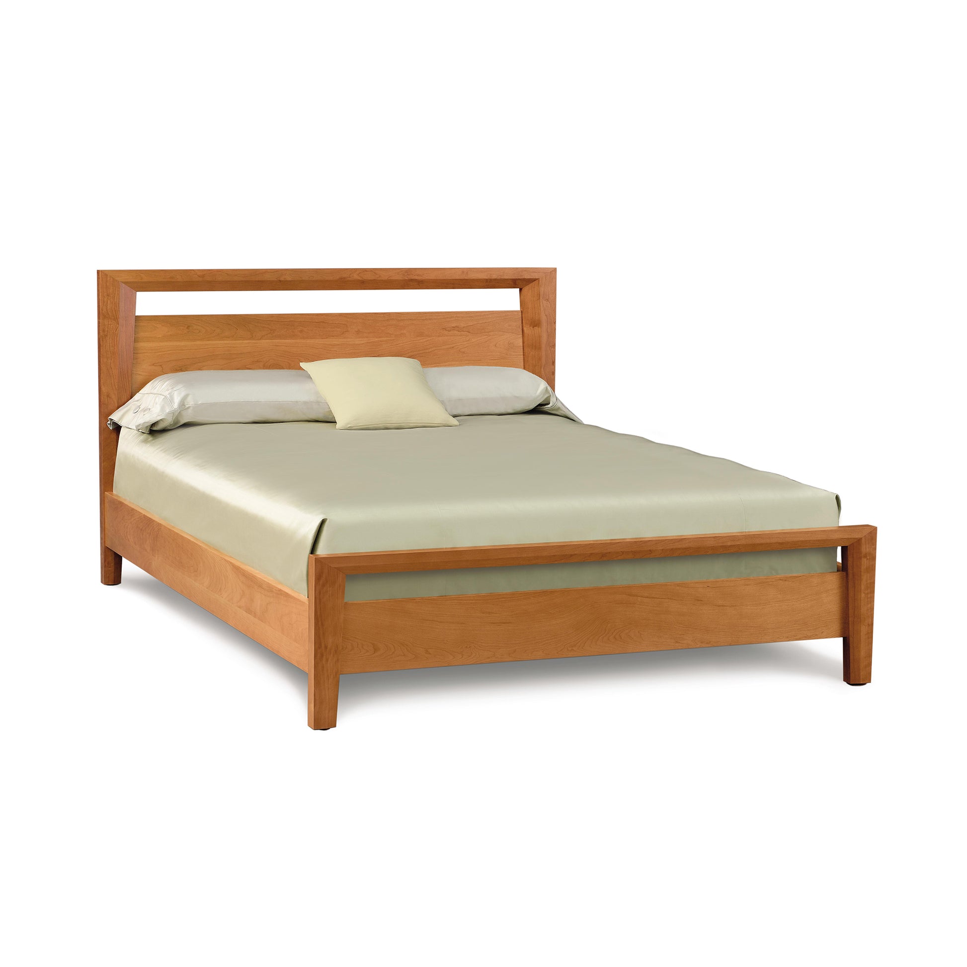 Copeland Furniture Mansfield Platform Bed in solid wood, featuring a simple headboard with a rectangular cutout, paired with a light green bedspread and green pillow.
