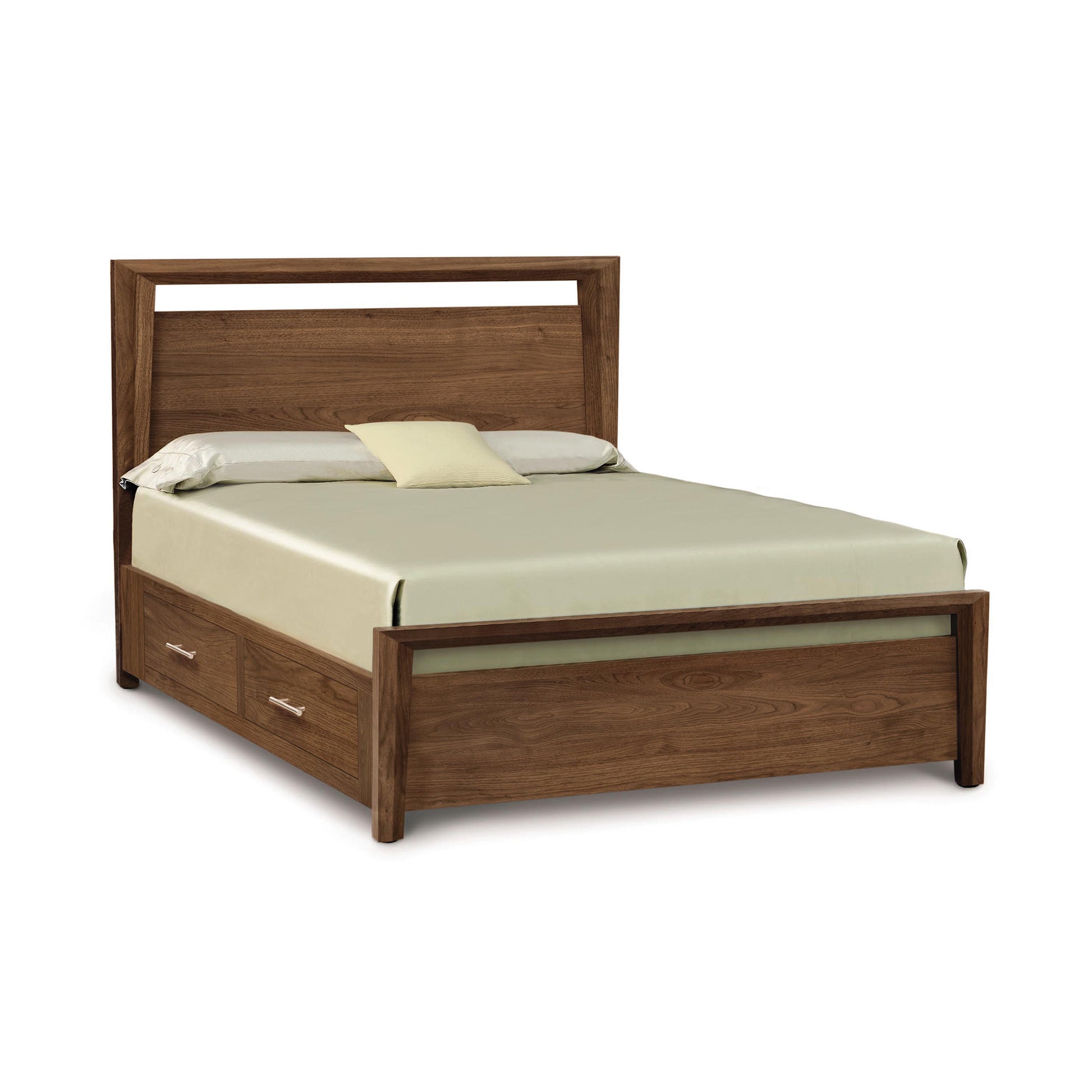 A Copeland Furniture Mansfield Walnut Storage Bed designed in the Arts & Crafts style, featuring solid wood construction with a simple headboard and two storage drawers at the foot, accompanied by a pale green bedsheet.