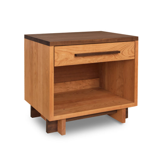 A Modern American 1-Drawer Enclosed Shelf Wide Nightstand from Vermont Furniture Designs, featuring a smooth finish with a single drawer at the top and an open shelf below. It stands on short, solid legs, has a dark top, and a lighter wood body.