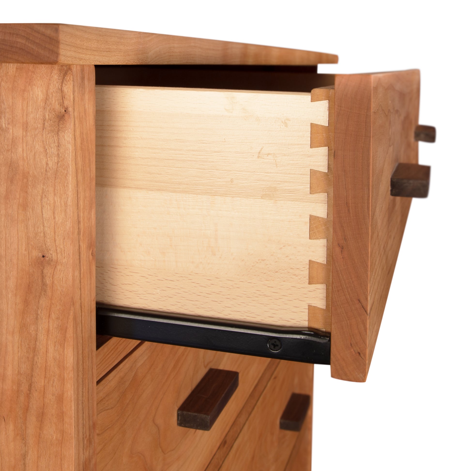 An open wooden drawer featuring dovetail joints, illustrating the craftsmanship and detail of the Vermont Furniture Designs Modern Craftsman 5-Drawer Chest.