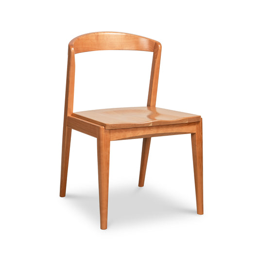 Vermont Woods Studios Montgomery Chair in natural cherry featuring a curved backrest and four straight legs, crafted from premium American hardwood.
