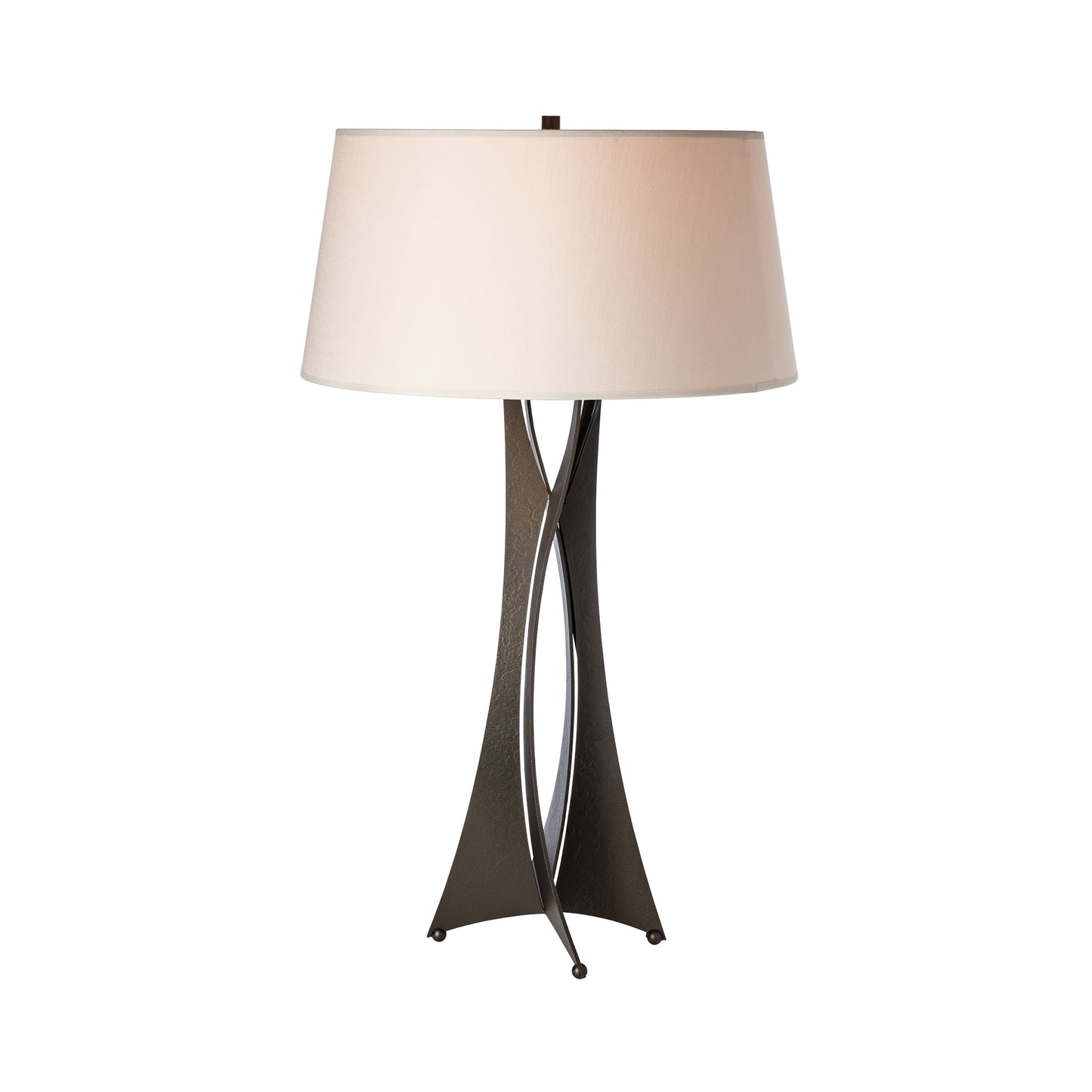 A Moreau Table Lamp by Hubbardton Forge with a beige lampshade and a dark brown, hand-crafted wrought iron base with three legs, isolated on a white background.