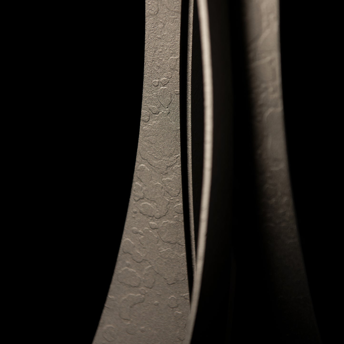 Hubbardton Forge Moreau Table Lamp showcasing its textured wrought iron surface and elegant curved edges.