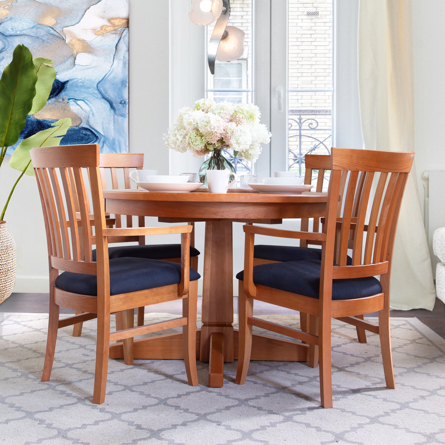Cherry wood table with Lyndon Furniture Bistro Dining Chairs featuring black cushions, showcasing fine craftsmanship and elegance.