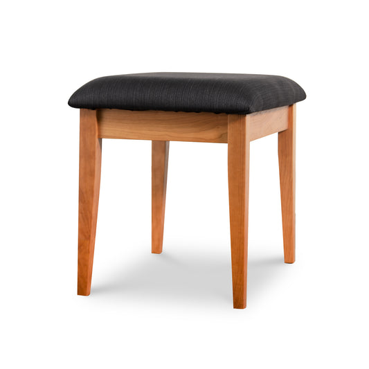 Lyndon Furniture New England Shaker Dressing Stool with four wooden legs and a black cushioned seat, crafted from sustainable wood.