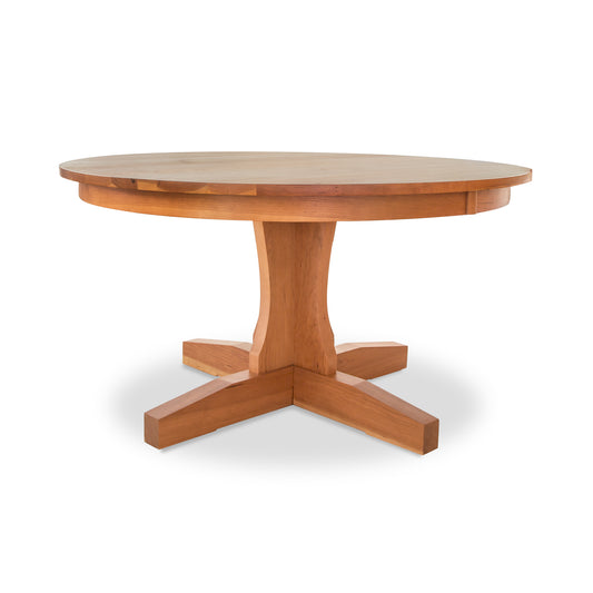 A New Traditions Round Pedestal Table from Lyndon Furniture, with a wooden base, crafted from hardwoods and featuring a natural finish.