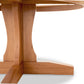 A Lyndon Furniture handmade New Traditions Round Pedestal Table with a wooden base and a natural finish.