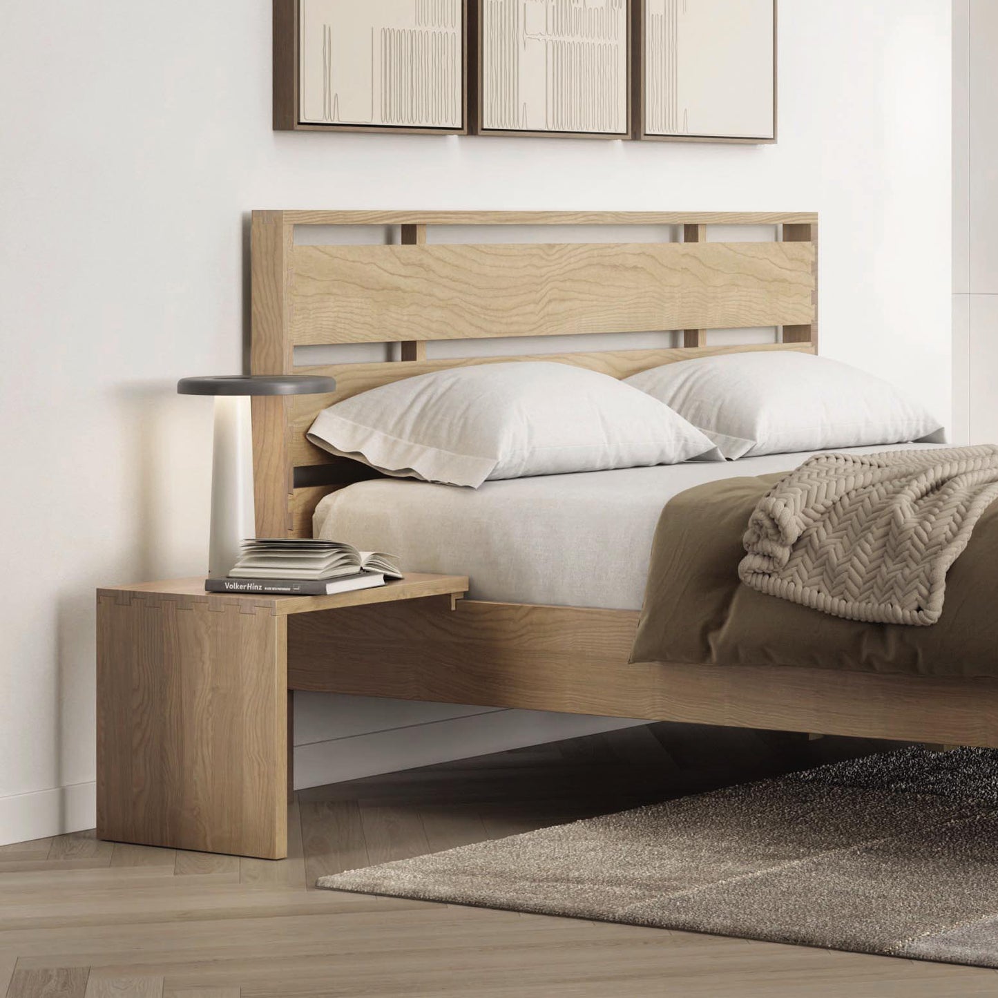 Solid oak bed frame with white bedding and beige blanket; Copeland Furniture nightstand with books and lamp.