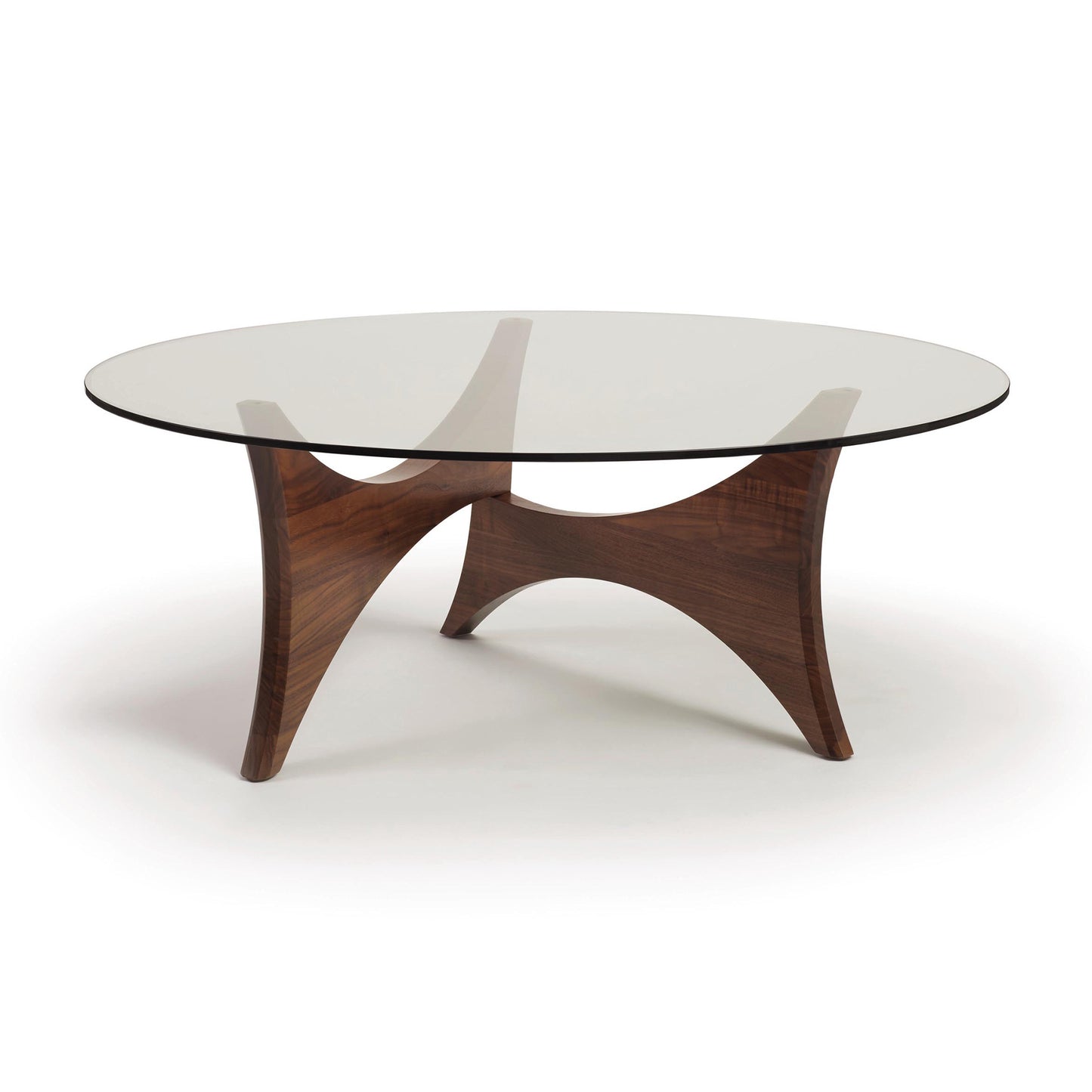 Pivot Round Coffee Table by Copeland Furniture with a glass top and sculpted walnut base, showcasing three elegant curved legs.