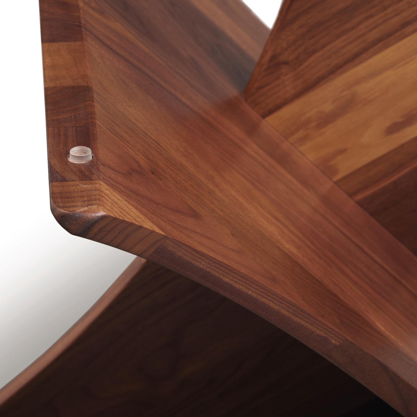 Planes Round Glass Top Coffee Table by Copeland Furniture, highlighting the walnut wood corner’s smooth angled craftsmanship and detailed joinery.