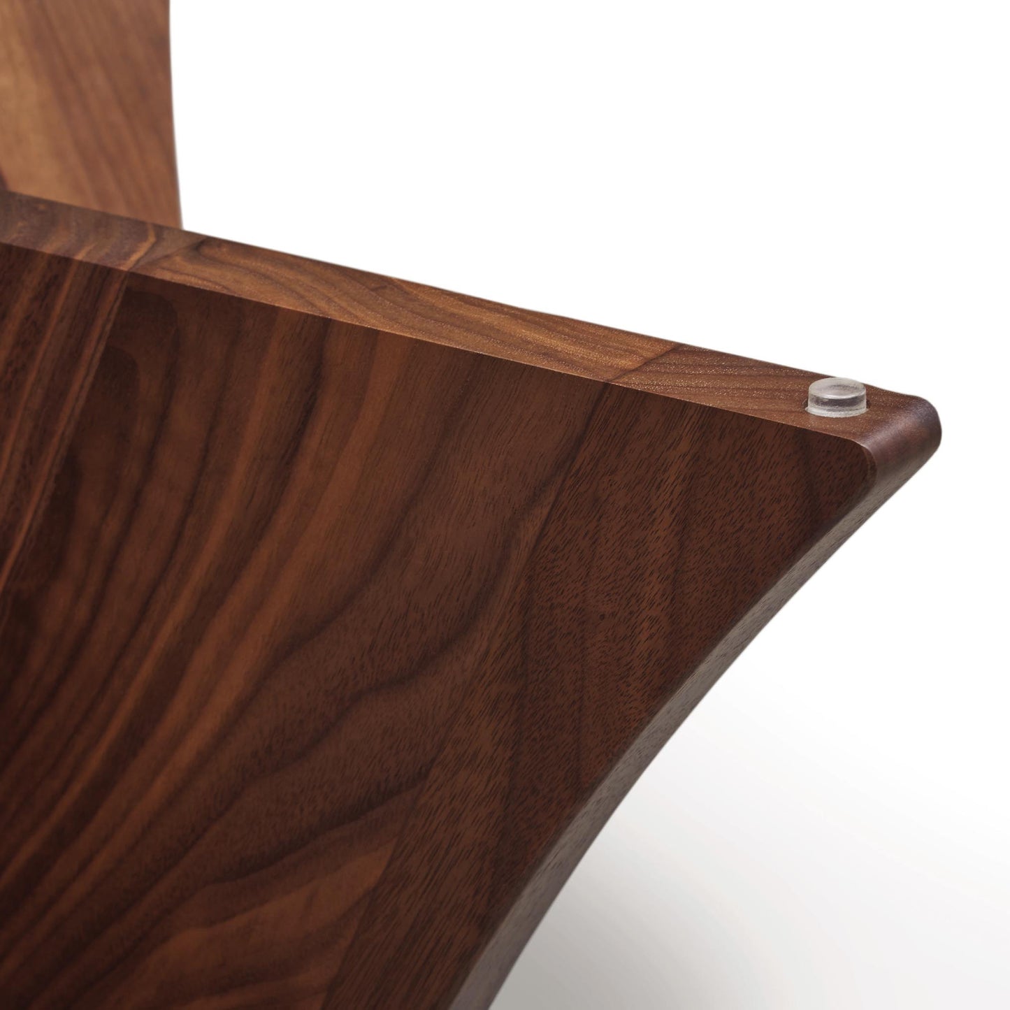 Copeland Furniture Planes round glass top end table highlighting its solid walnut corner, smooth edge detail, and exposed metal bolt.