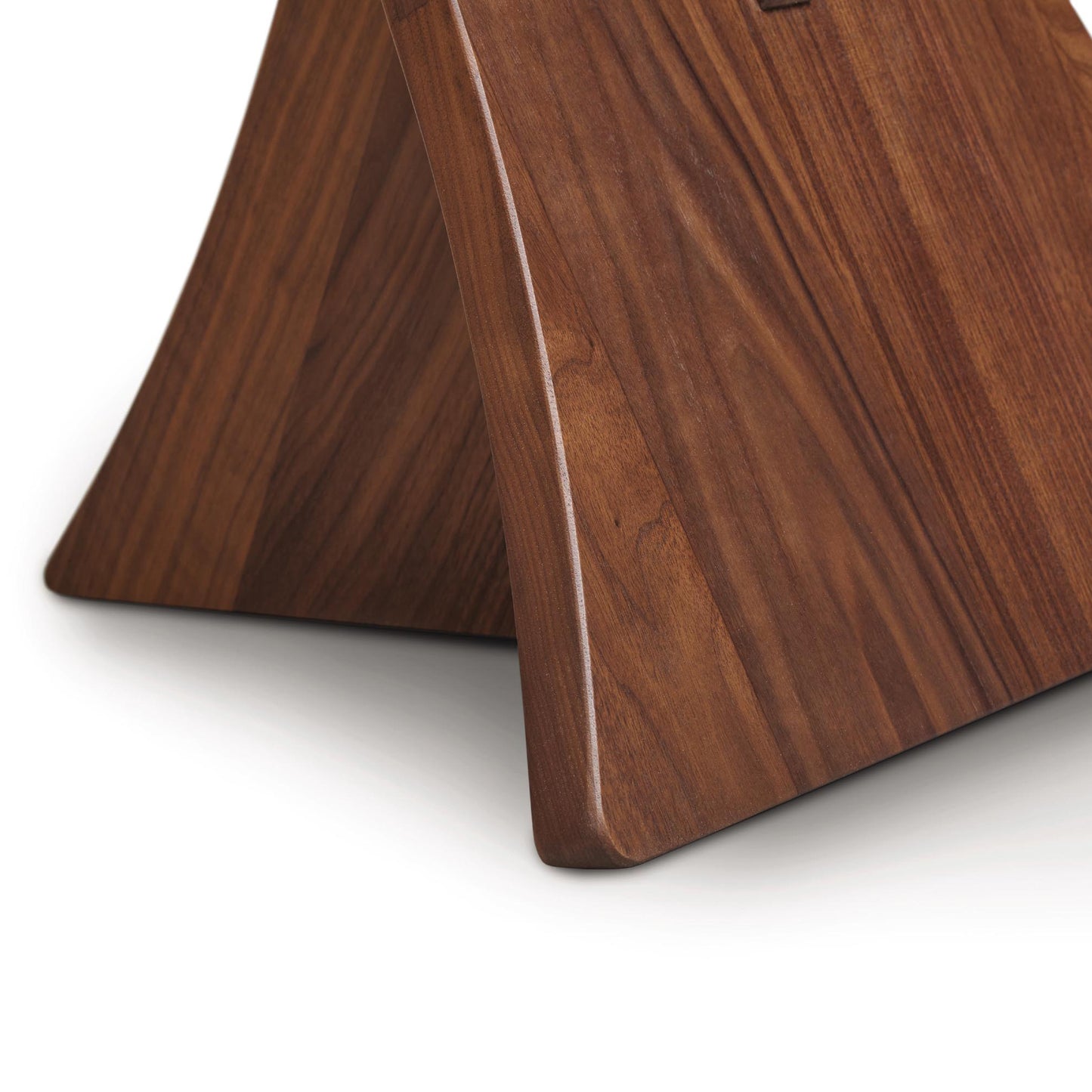 Copeland Planes Round Glass Top End Table with elegantly curved walnut base and rich wood grain, showcasing fine craftsmanship.
