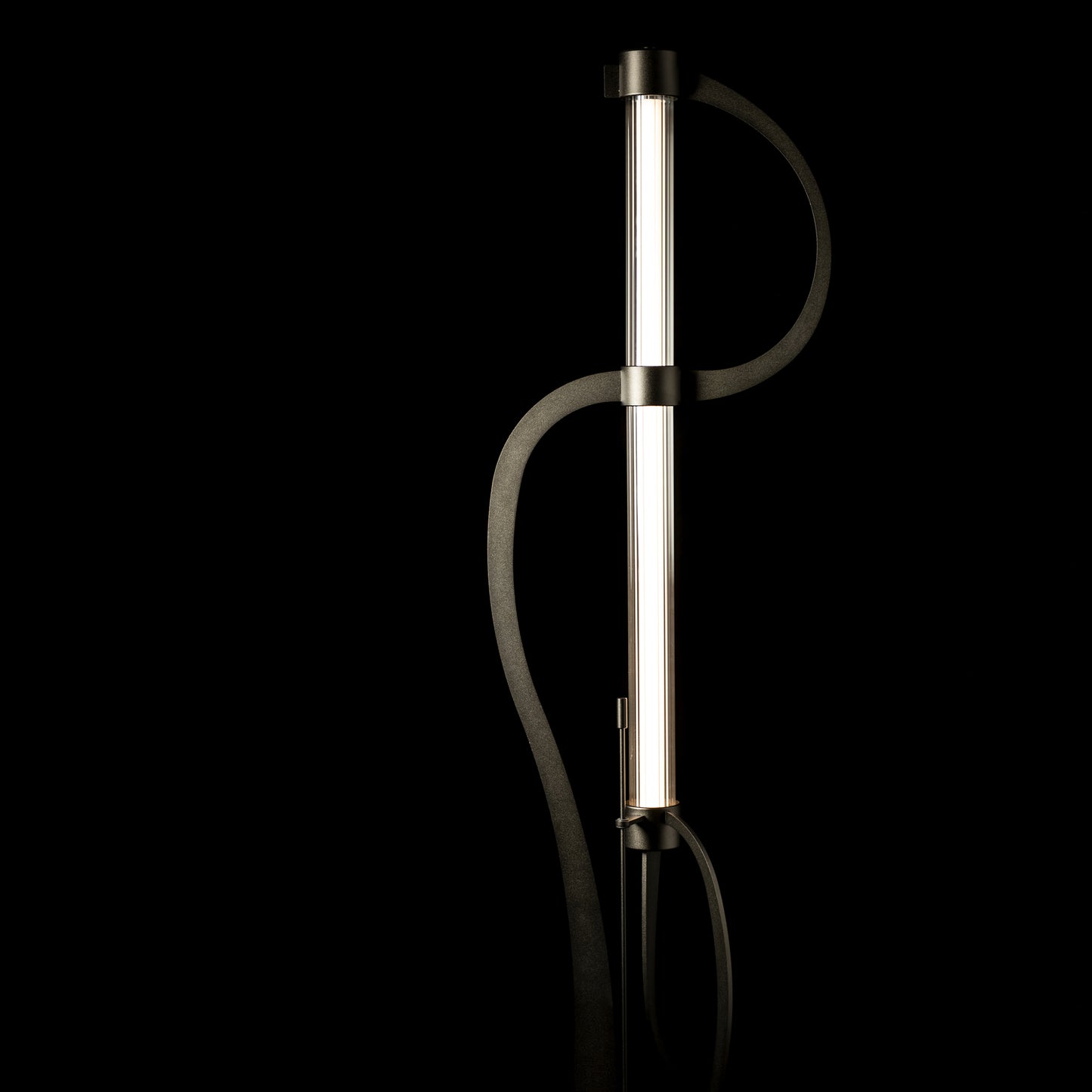 Hubbardton Forge Pulse Floor Lamp featuring a sleek black curving frame, highlighting its tall, modern LED design.
