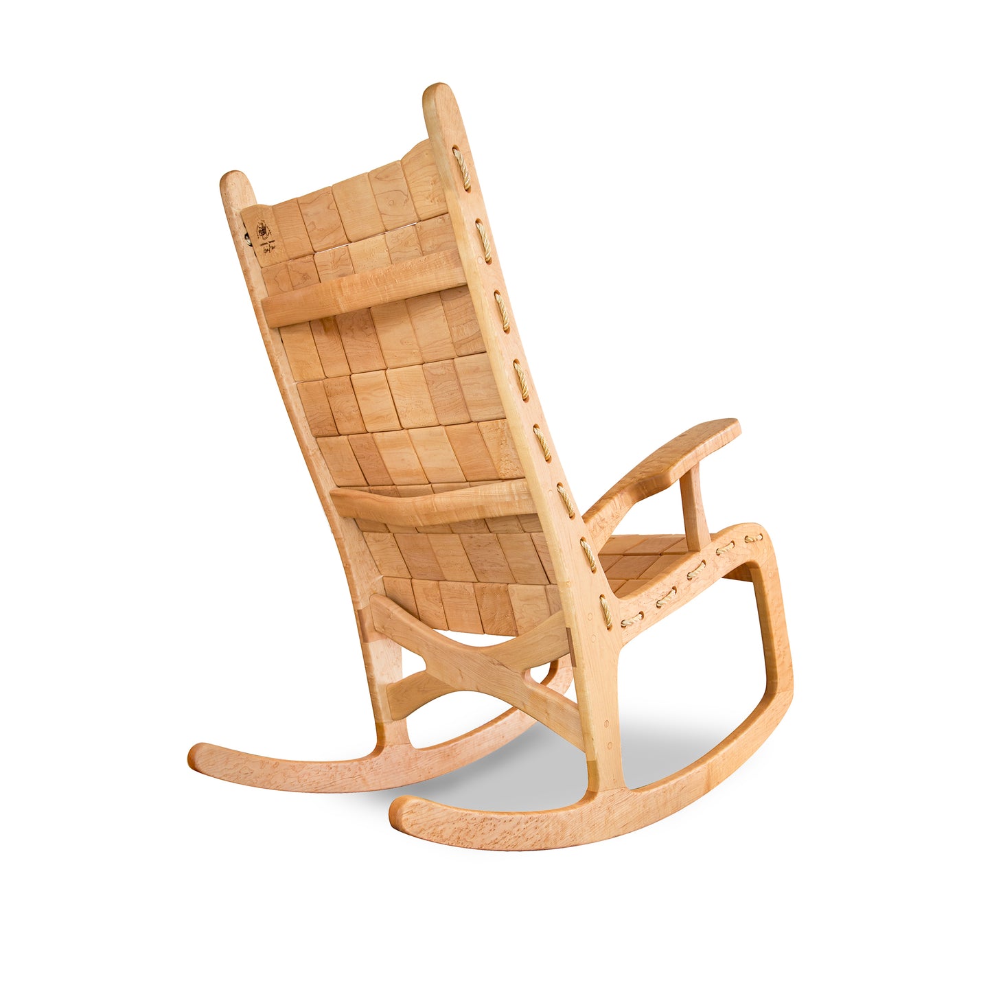 A wooden Vermont Folk Rocker rocking chair made from birdseye maple with a quilted seat and backrest, angled back for comfort, and smoothly curved rockers. The chair is set against a white background.